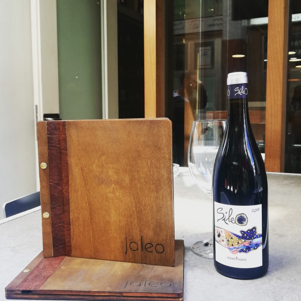 Cartas de madera con lomo marrón junto a una botella