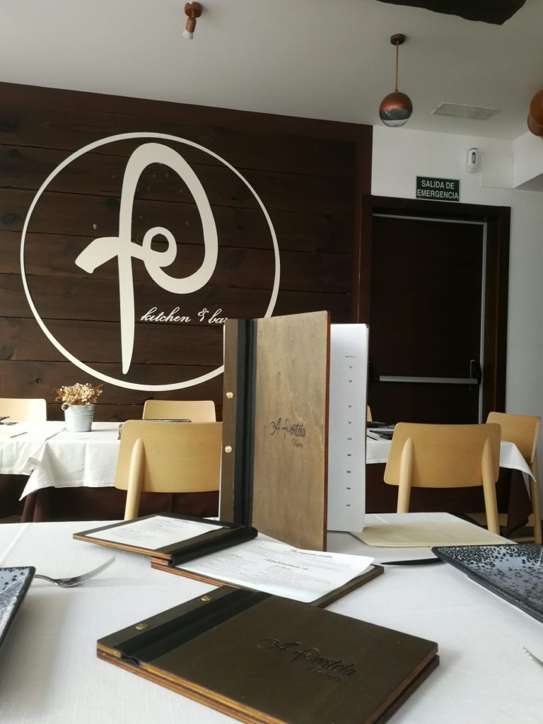 Cartas de madera con lomo oscuro sobre mesas de restaurante